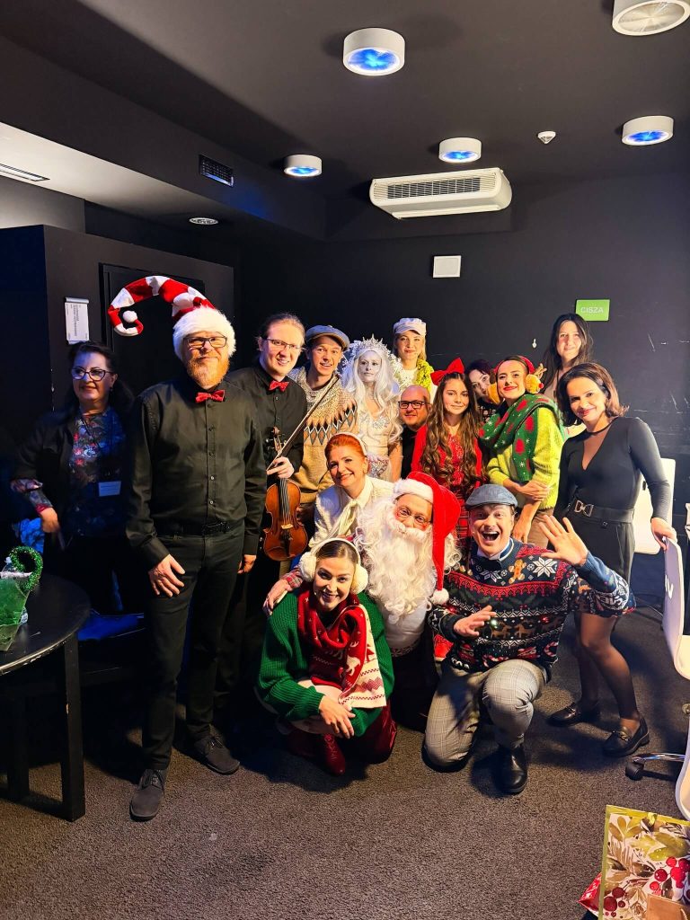 Zespół teatralny w świątecznych strojach pozujący do zdjęcia w garderobie