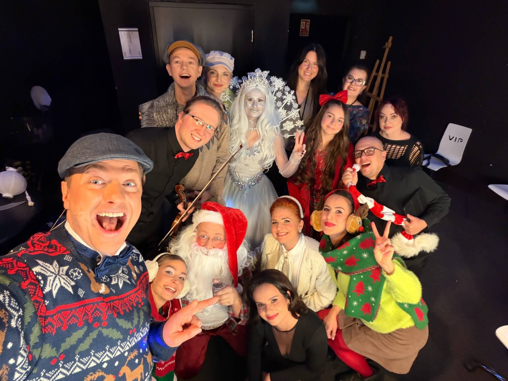 Grupa artystów w świątecznych kostiumach robiąca wspólne zdjęcie za kulisami teatru