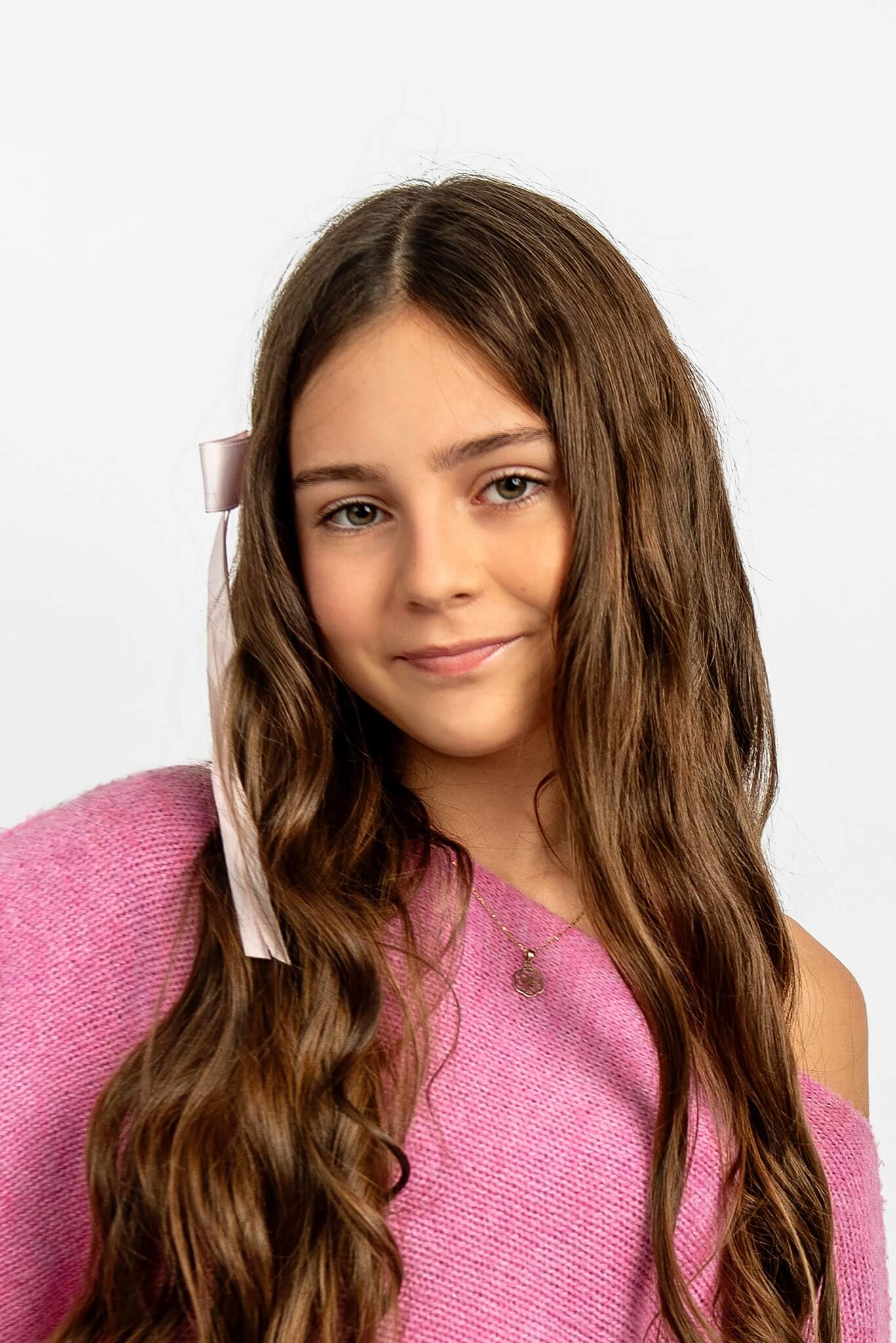 Portret dziewczynki z długimi brązowymi włosami na jasnym tle