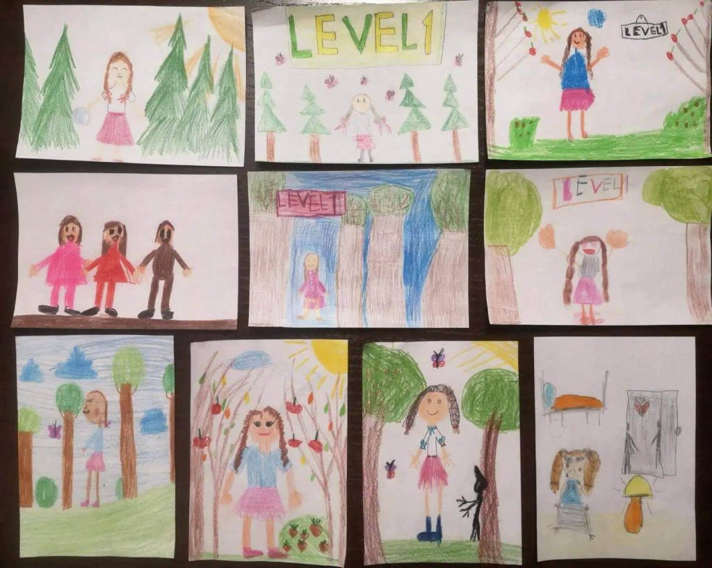 Rysunki dzieci pokazujące Karolcię w leśnym otoczeniu.